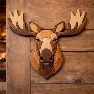 May include: A wooden moose head wall art piece. The moose is crafted from various shades of wood, including light tan, medium brown, and dark brown. The antlers are a lighter shade of wood, and the eyes are detailed. The piece is mounted on a wooden surface.