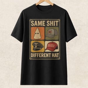 May include: Black t-shirt with the text "SAME SHIT DIFFERENT HAT" above and below four images of hats: a white hood, a gray baseball cap, a black military hat, and a red baseball cap.
