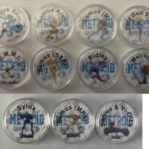 May include: A collection of twelve clear plastic coin holders, each featuring a different character from the Metroid video game series. The characters are depicted in various action poses, with text labels above and below each image.