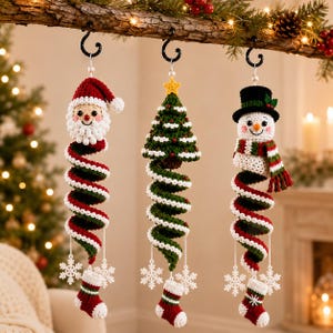 Può includere: Tre ornamenti all'uncinetto da appendere raffiguranti Babbo Natale, un albero di Natale e un pupazzo di neve. Ogni figura ha un corpo a spirale rosso, verde e bianco, decorato con fiocchi di neve all'uncinetto e una calza in miniatura.