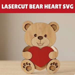 May include: A wooden bear-shaped decoration holding a red heart. The bear is made of light brown wood with paw prints on its feet. The text "LASERCUT BEAR HEART SVG" is displayed in white letters on a red banner above the bear.