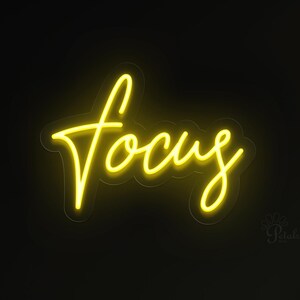 May include: A neon sign in a cursive font spelling the word "focus" in bright yellow against a black background. The sign is illuminated, creating a vibrant and eye-catching display. The sign is mounted on a dark wall.