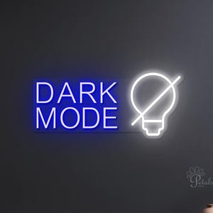 May include: A neon sign displaying "DARK MODE" in blue, alongside a white lightbulb symbol with a line through it. The sign is mounted on a dark grey wall above a black cabinet with decorative vases.