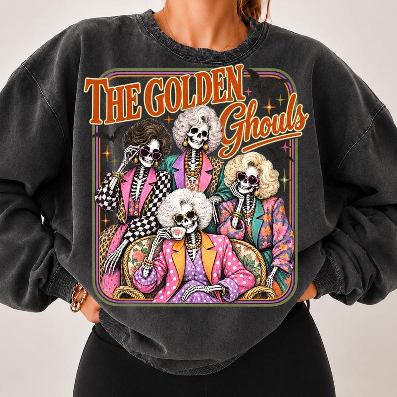 A person wearing a black sweatshirt with a graphic design featuring four stylized women with skeletal features and colorful outfits.