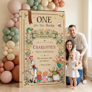 May include: A large, rectangular, book-shaped birthday sign featuring the text 'ONE for the Books', 'Charlotte's FIRST BIRTHDAY', and 'You are braver than you believe.' The sign is decorated with illustrations of storybook characters and floral vines.