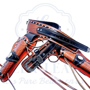 Peut inclure: Ensemble de holster en cuir marron avec ceinture, deux étuis et une boucle de ceinture. Les étuis présentent un motif de tissage en panier et sont rehaussés de cuir noir et de clous argentés. L'ensemble est sur le thème western.