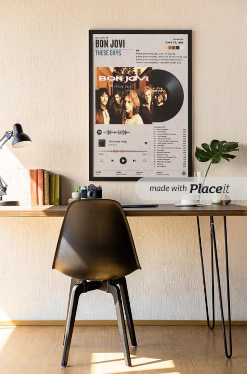 May include: A framed wall poster featuring the Bon Jovi album These Days, displaying the band members, a vinyl record graphic, tracklist, and release date of June 27, 1995, set against a light gray background with black text and accents.