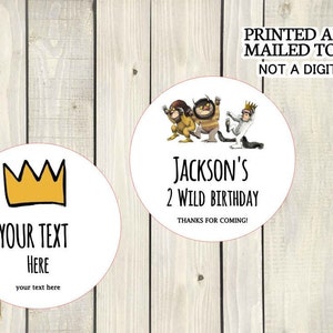 May include: Two round white stickers with black text. One sticker features a yellow crown and the text "YOUR TEXT HERE" with the words "your text here" below. The other sticker features a cartoon illustration of three characters from the book "Where the Wild Things Are" and the text "JACKSON'S 2 WILD BIRTHDAY" with the words "THANKS FOR COMING!" below.