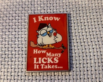 Peut inclure: Épinglette rectangulaire avec un fond rouge et le texte "I Know How Many LICKS It Takes...". L'épinglette représente un hibou de dessin animé portant des lunettes et un chapeau de remise de diplôme, perché sur une branche.