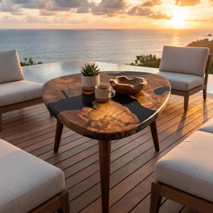 May include: A wooden coffee table with a unique design, featuring a dark epoxy resin inlay. The table is supported by three wooden legs and is surrounded by outdoor seating. A small succulent plant, a mug, and a wooden bowl are on the table.