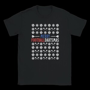 Puede incluir: Camiseta negra con un diseño festivo. El diseño incluye balones de fútbol, copos de nieve y dardos, con las palabras "MERRY FOOTBALLDARTSMAS" en rojo y azul. Una divertida camiseta navideña.