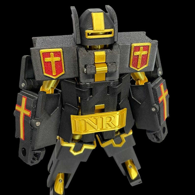 May include: A black and gold robot toy with red cross emblems. The robot has a gold "INR" emblem on its chest and gold accents on its joints and head. The robot's arms and legs are articulated.