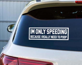 May include: White rectangular car decal with the text "IM ONLY SPEEDING BECAUSE I REALLY NEED TO POOP" in a black font. The decal is affixed to the rear window of a white car.