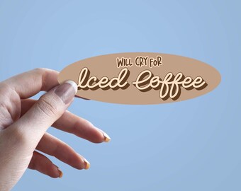May include: An oval-shaped sticker with the text "WILL CRY FOR Iced Coffee" in a brown and cream color scheme. The sticker is held against a light blue background.