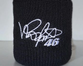Peut inclure: Poignet noir avec une signature brodée blanche et le numéro 46. Le poignet est fait d'un matériau absorbant texturé, probablement pour le sport. Le design est simple et audacieux.