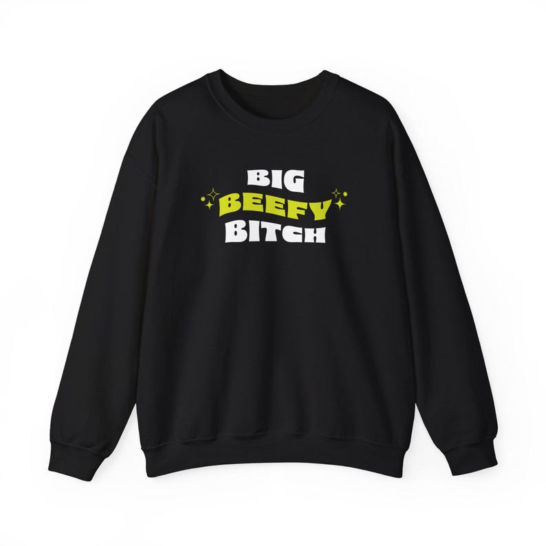 K&ouml;nnte beinhalten: Schwarzer Pullover mit einem wei&szlig;en Aufdruck, der "BIG BEEFY BITCH" in einer gelben Retro-Schrift mit Sternen auf beiden Seiten zeigt.