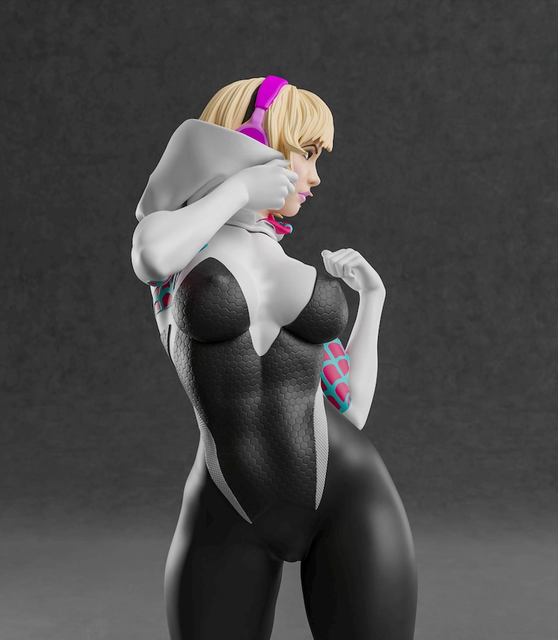 K&ouml;nnte beinhalten: Figur einer Superheldin in einem schwarz-wei&szlig;en Body mit Spinnennetz-Muster. Die Figur hat blondes Haar, pinkfarbene Kopfh&ouml;rer und pinkfarbene und blaue Akzente an den Armen. Die Figur befindet sich in einer dynamischen Pose.