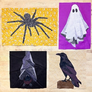 Könnte beinhalten: Vier Stoffquadrate mit verschiedenen Halloween-Motiven im Paper-Piecing-Stil. Die Quadrate zeigen eine schwarze Spinne auf gelbem Hintergrund, ein weißes Gespenst auf lila Hintergrund, eine schwarze Fledermaus auf schwarzem Hintergrund und einen schwarzen Raben auf beigefarbenem Hintergrund.