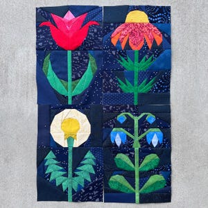May include: A patchwork quilt with four floral designs: a red tulip, a pink and orange coneflower, a yellow dandelion, and blue bellflowers. The background is a dark blue fabric with a starry pattern.