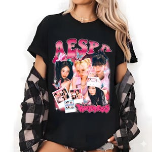 Könnte beinhalten: Schwarzes T-Shirt mit einem rosa Aufdruck mit dem Wort "AESPA" und "Hotness" unter einem Foto von vier Frauen. Das Design enthält Schmetterlinge und einen Retro-Stil.