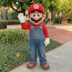 Pu&ograve; includere: Una persona in costume da Mario, che saluta. Il costume comprende un cappello rosso con una "M" bianca, una maglia rossa a maniche lunghe, una salopette di jeans blu, guanti bianchi e scarpe marroni. Il personaggio ha grandi baffi neri e occhi blu.