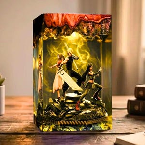 May include: A rectangular lamp featuring a Final Fantasy scene with three characters, set against a yellow and orange background. The lamp has a detailed base and a textured top, creating a vibrant and illuminated display.