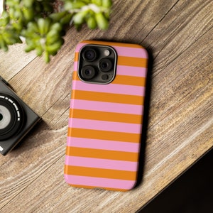 Op de afbeelding: Een roze en oranje gestreepte telefoonhoes voor een iPhone.