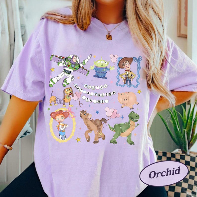 Pu&ograve; includere: T-shirt lilla chiaro con personaggi di Toy Story. Il design include Buzz Lightyear, Woody e altri personaggi, insieme al testo "You've Got a Friend in Me". Un capo comodo e casual.