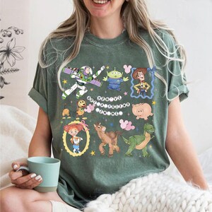 Pu&ograve; includere: T-shirt verde con personaggi dei cartoni animati del film Toy Story. La maglietta include Buzz Lightyear, Woody, un alieno, Jessie, Hamm, Rex e Bullseye. Il testo "You've Got a Friend in Me" &egrave; anch'esso visualizzato sulla maglietta.
