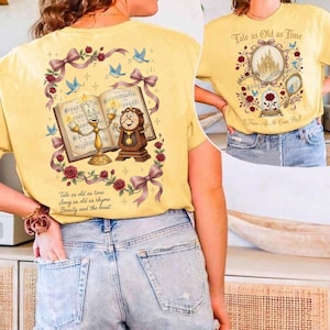 May include: Yellow t-shirts with a Beauty and the Beast theme. One shirt features Lumiere and Cogsworth with sheet music, roses, and the text "Tale as old as time." The other shirt has a castle, rose, and the text "True As It Can Be."