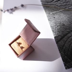 May include: A pair of small ruby earrings in a velvet jewellery box.