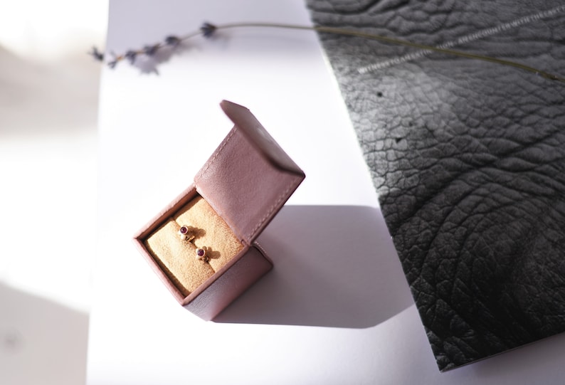 May include: A pair of small ruby earrings in a velvet jewellery box.