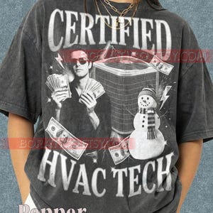Könnte beinhalten: Dunkelgraues T-Shirt mit dem Text "CERTIFIED HVAC TECH". Das Design zeigt eine Person mit Geld, ein Klimagerät und einen Schneemann. Blitze und Geldscheine sind ebenfalls Teil des Designs.