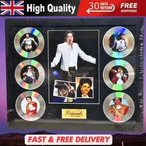 Puede incluir: Recuerdos enmarcados de Michael Jackson con una foto central e imágenes en discos con forma de CD. La imagen central muestra a Michael Jackson con una chaqueta blanca. Los discos muestran varias fotos de actuaciones. El marco tiene el texto "Legends of music".