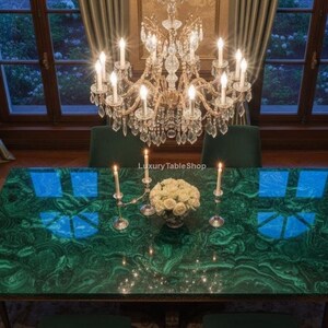 May include: A dining room with a large, rectangular table featuring a malachite green surface. Four green chairs surround the table, which is set with candles and a floral arrangement. A crystal chandelier hangs above.