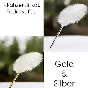 May include: Two feather pens with white plumes, one featuring a silver-toned metal barrel and the other a gold-toned metal barrel. The text Nikahzertifikat Federstifte and Gold & Silber is displayed in the image.