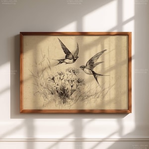 Könnte beinhalten: Ein gerahmter Vintage-Druck mit zwei Schwalben im Flug über einem Feld aus Blumen und Gras. Das Kunstwerk ist in Schwarzweiß gehalten, vor einem sepiafarbenen Hintergrund, und in einem braunen Holzrahmen eingefasst.