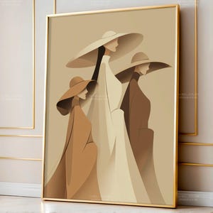 Op de afbeelding: Een ingelijste kunstdruk met een minimalistische illustratie van drie figuren met breedgerande hoeden en lange jassen. Het kleurenpalet omvat tinten beige, bruin en wit, wat een verfijnde en elegante uitstraling creëert. Het kunstwerk is ingelijst in een goudkleurige lijst.
