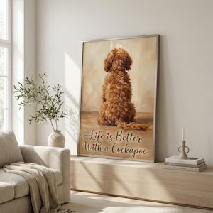 May include: A framed print showing a brown Cockapoo dog from behind. The artwork has a warm, neutral colour palette. The text "Life is Better With a Cockapoo" is written in a cursive font with red hearts.