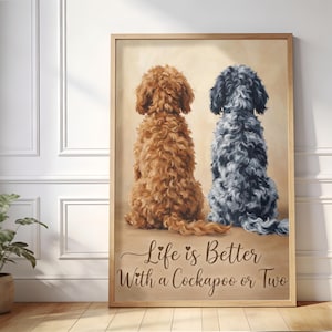 Puede incluir: Impresión enmarcada que presenta dos perros Cockapoo, uno marrón y otro gris, sentados uno al lado del otro. La obra de arte tiene un fondo neutro e incluye el texto "Life is Better With a Cockapoo or Two". El marco es de color madera clara.