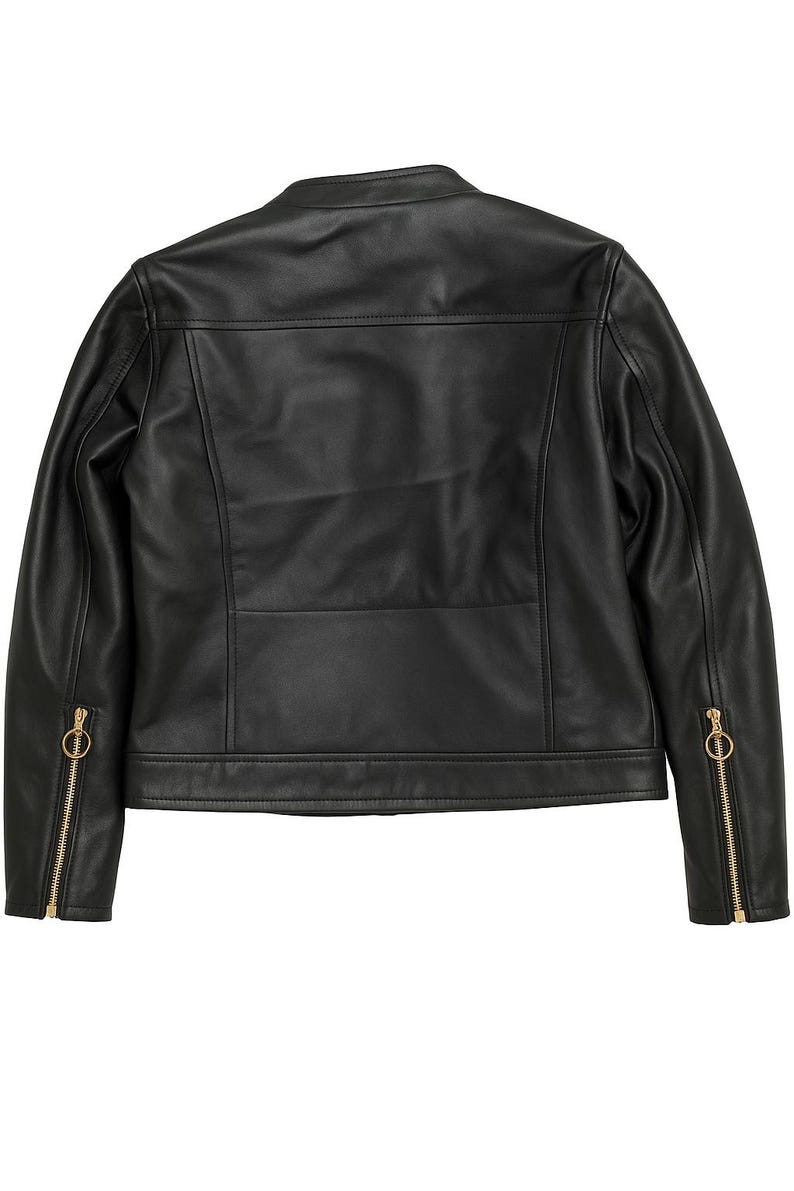 May include: Black leather jacket with a round collar and gold-colored zippers on the sleeves. The back of the jacket features a horizontal seam across the upper back and a vertical seam down the center.