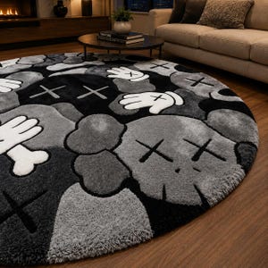 May include: A circular rug with a repeating pattern of cartoon figures in grey, black, and white. The rug has a soft texture and a contemporary design, suitable for a living room or bedroom. The rug's diameter is approximately 200 cm.