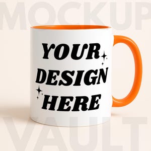 May include: White ceramic mug with an orange interior and handle. The mug features the text "YOUR DESIGN HERE" in bold black letters with star accents, perfect for custom designs.