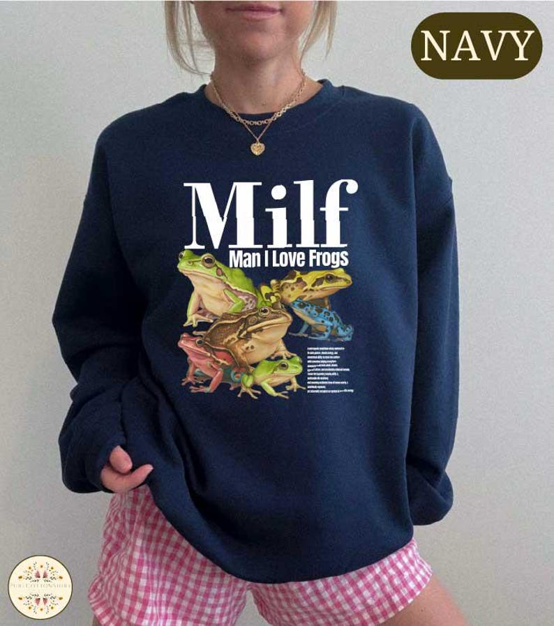 A navy blue sweatshirt with a graphic design of various colorful frogs.