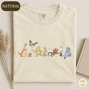 A t-shirt with a printed design of various Winnie the Pooh characters, including Tigger, Tigger's friend, and other beloved characters.