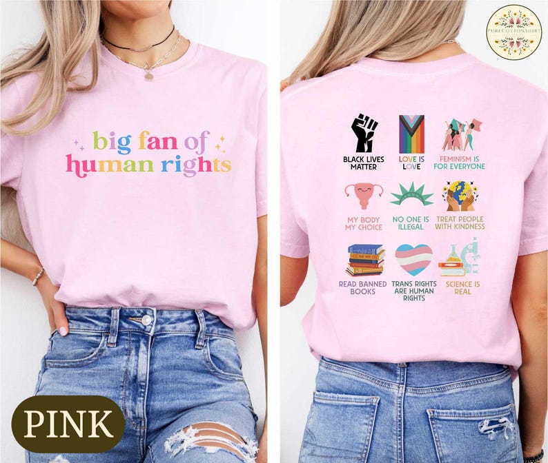 May include: Pink t-shirt with the text "big fan of human rights" in rainbow colors on the front. The back of the shirt features various graphic icons and phrases, including "Black Lives Matter" and "Love is Love".