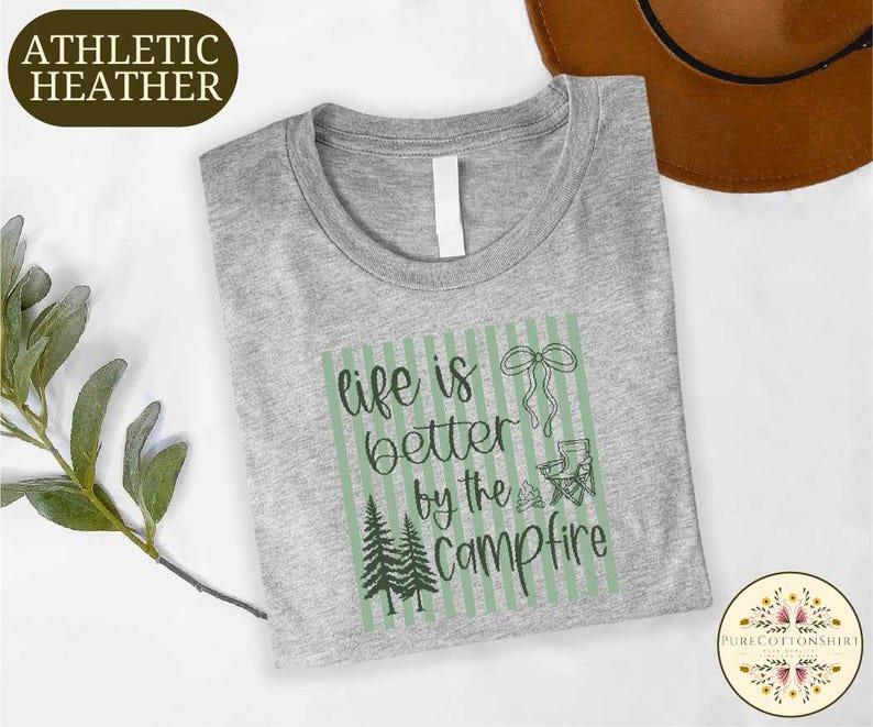 a gray t-shirt with a green and white graphic design, along with a brown hat and some greenery, all placed on a white background.