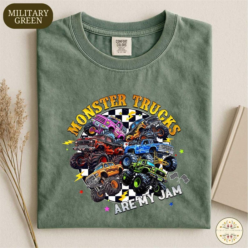 A military green t-shirt with a graphic design of various monster trucks and the text "MONSTER TRUCKS ARE MY JAM" printed on it.