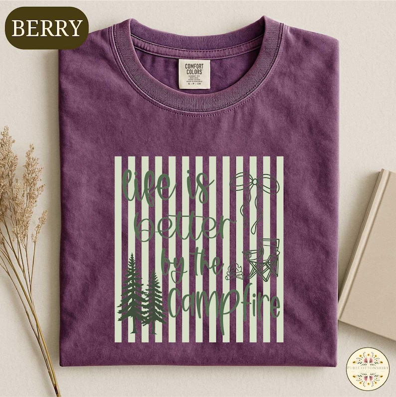 a purple t-shirt with a graphic design on it, which includes a quote and some forest-related elements.