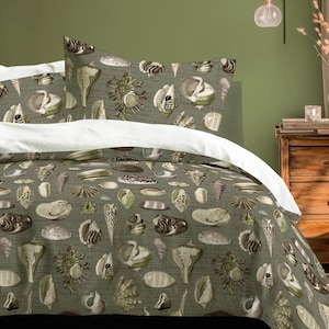 May include: Bedding set with a seashell pattern in grey, brown, and cream on a muted green background. The bed includes a duvet cover and two pillowcases, with white sheets. The room features a wooden bedside table and a green wall.